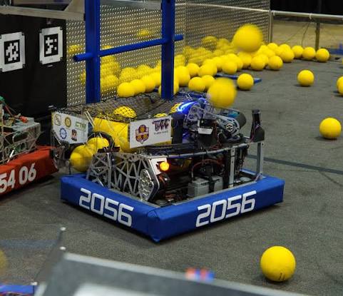 Team 2056 robot driving among yellow game pieces on the competition field